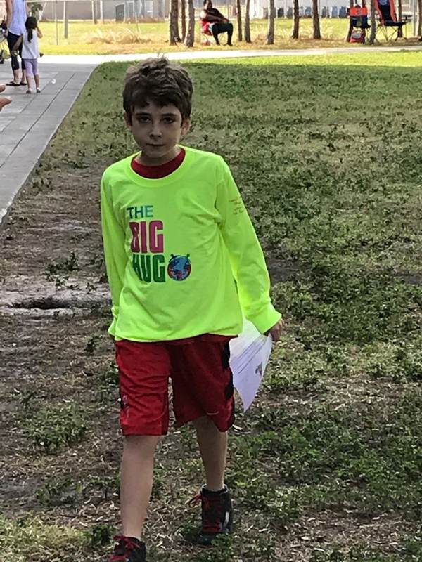 A child in a bright shirt on a grassy field.