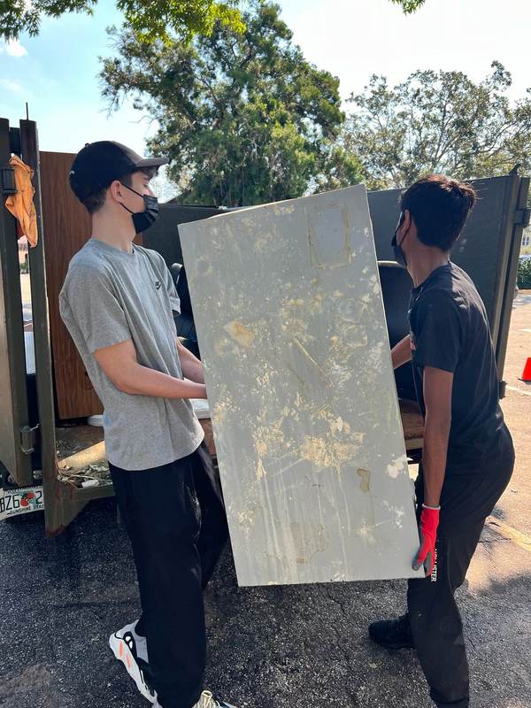 Volunteers carrying a panel through a doorway.