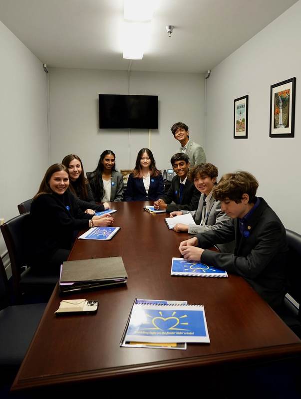 Students around a conference table in a Capitol office.