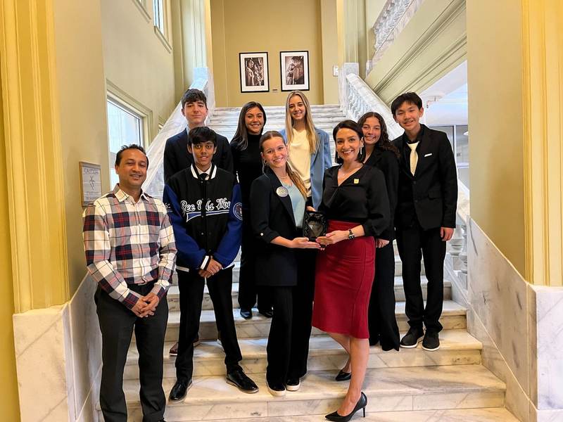 The group on a marble staircase with an official.