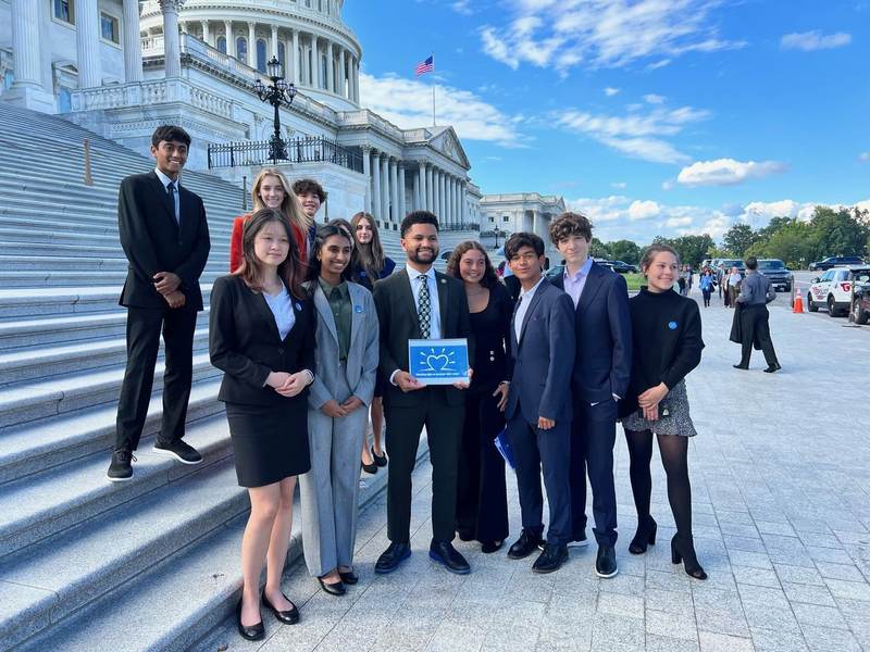 The group on the Capitol steps with folders.