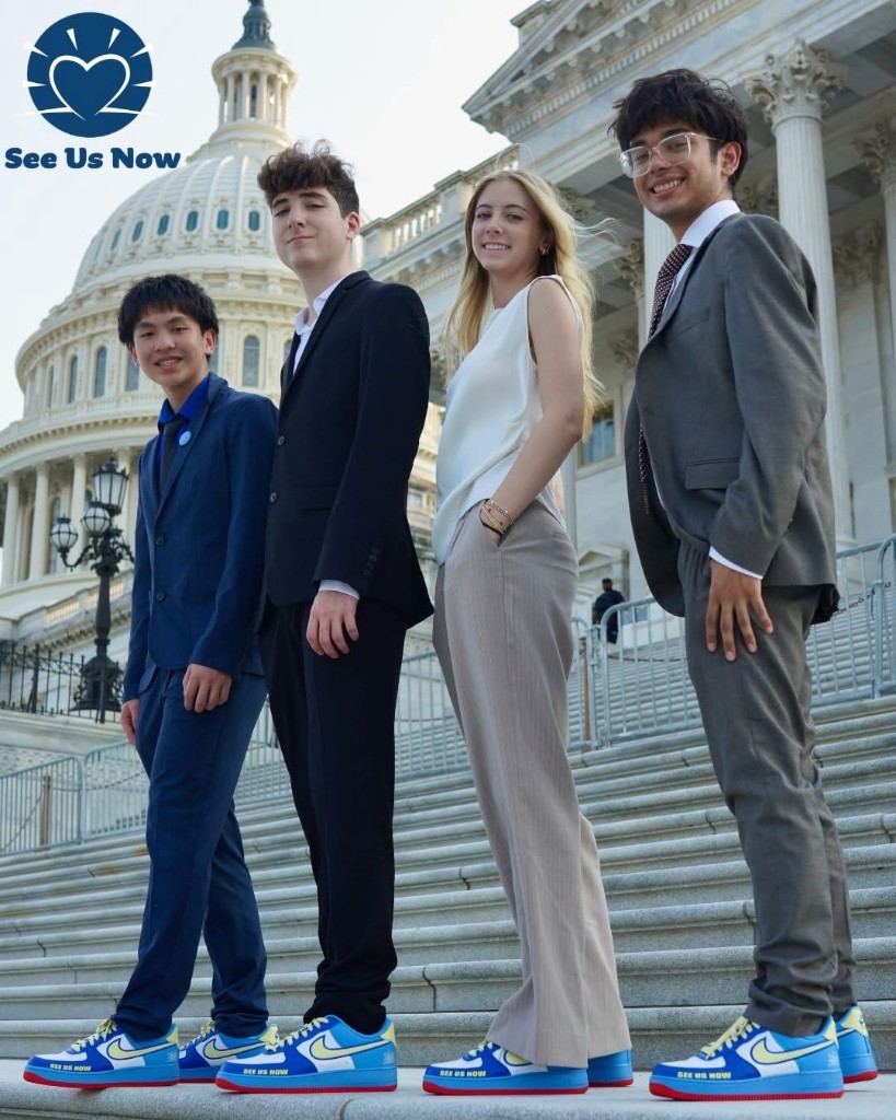 See Us Now members on the steps of the U.S. Capitol, in blue and yellow sneakers.
