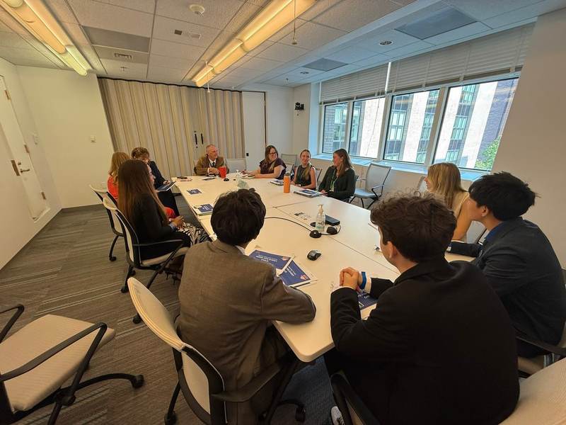 Students seated around a conference table.