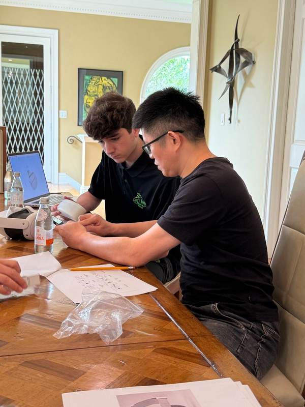 Two students working through papers at a table.